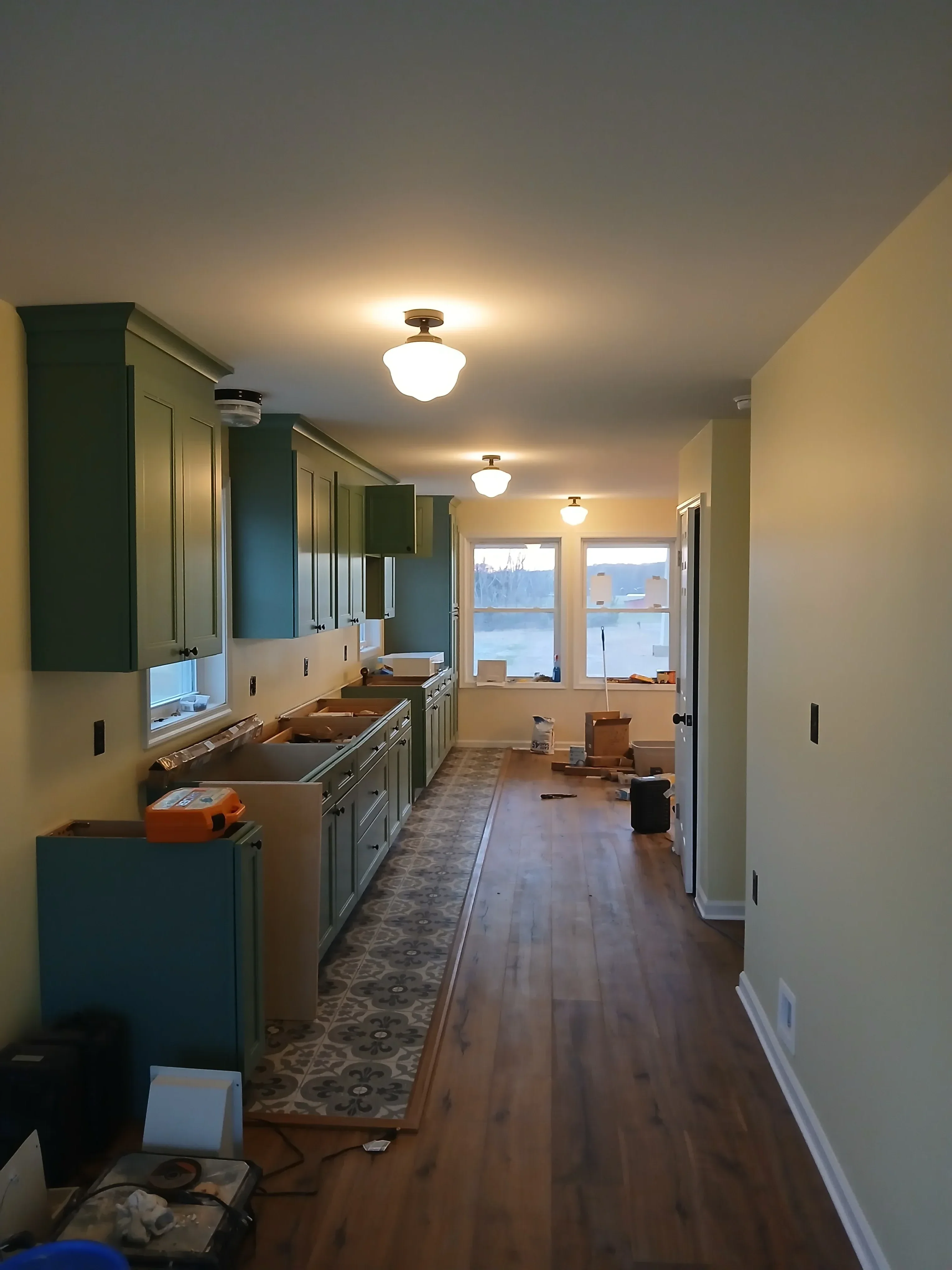 Kitchen renovation with teal cabinetry, tile backsplash, recessed lighting, and painted drywall