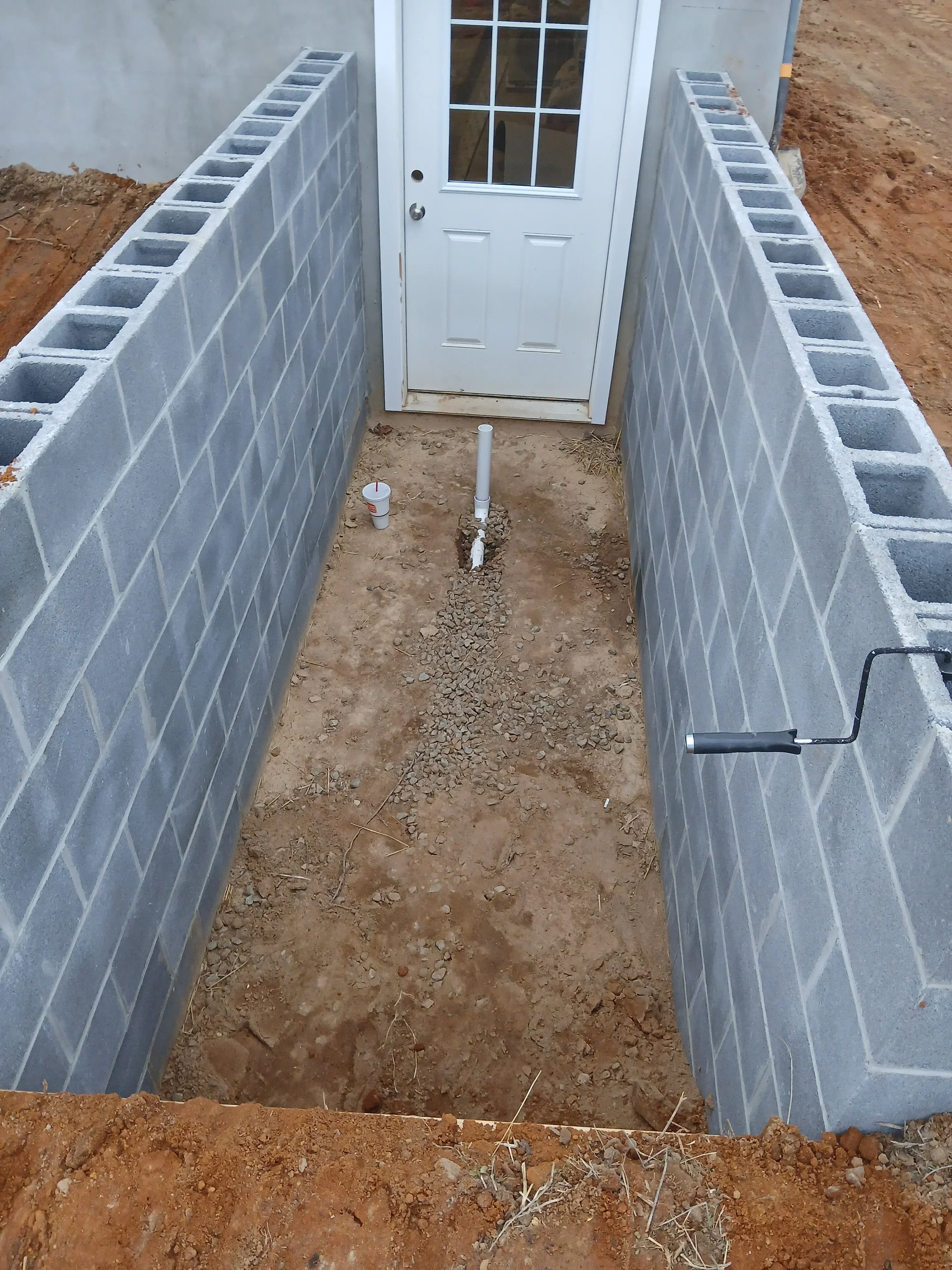 Concrete garage foundation with ventilation blocks and white garage door installation