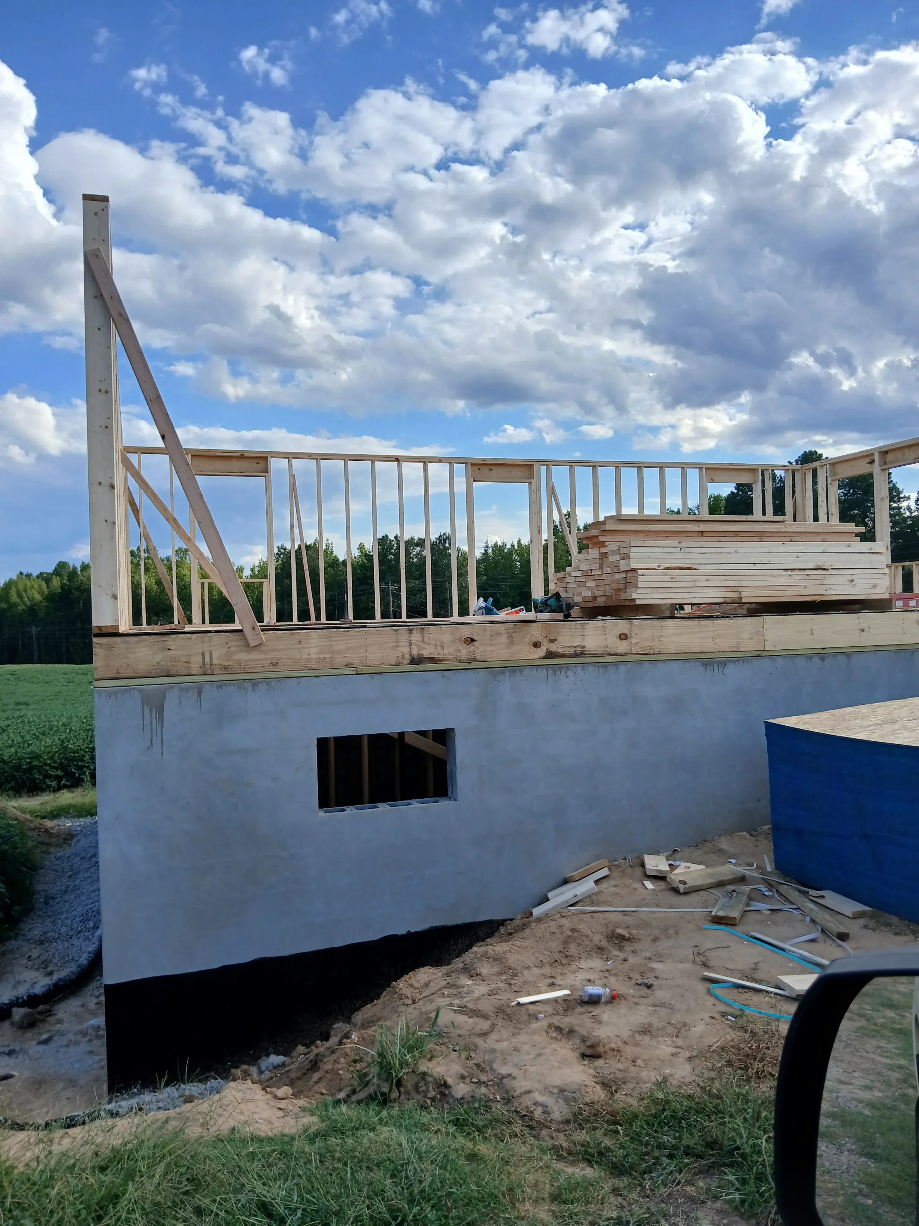 Concrete foundation with wooden floor joists and roof framing during residential construction