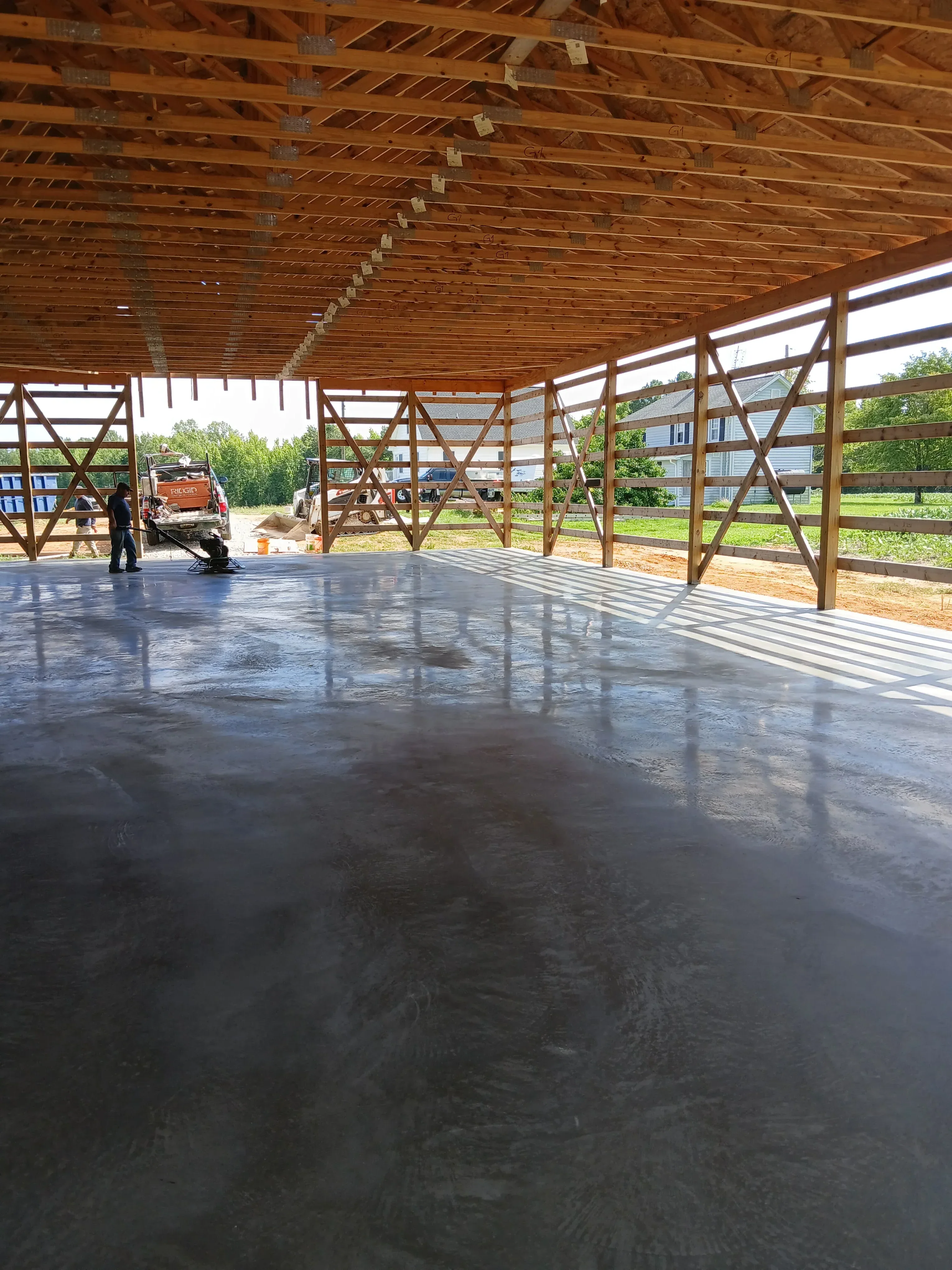 Steel frame barn with diagonal bracing, metal roofing, and corrugated siding under construction