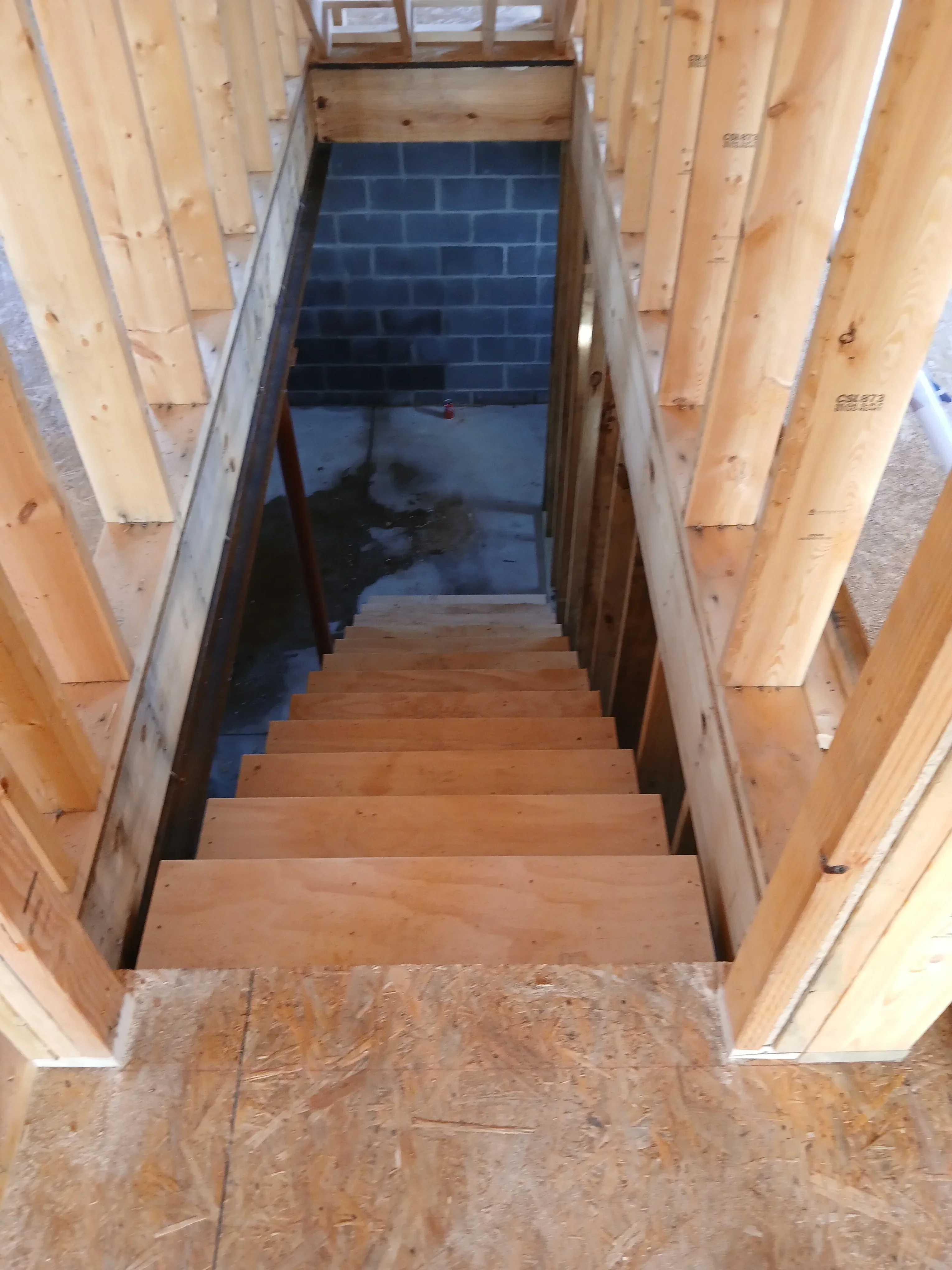 Wooden beam framing with lumber joists, posts, and OSB sheathing during interior construction
