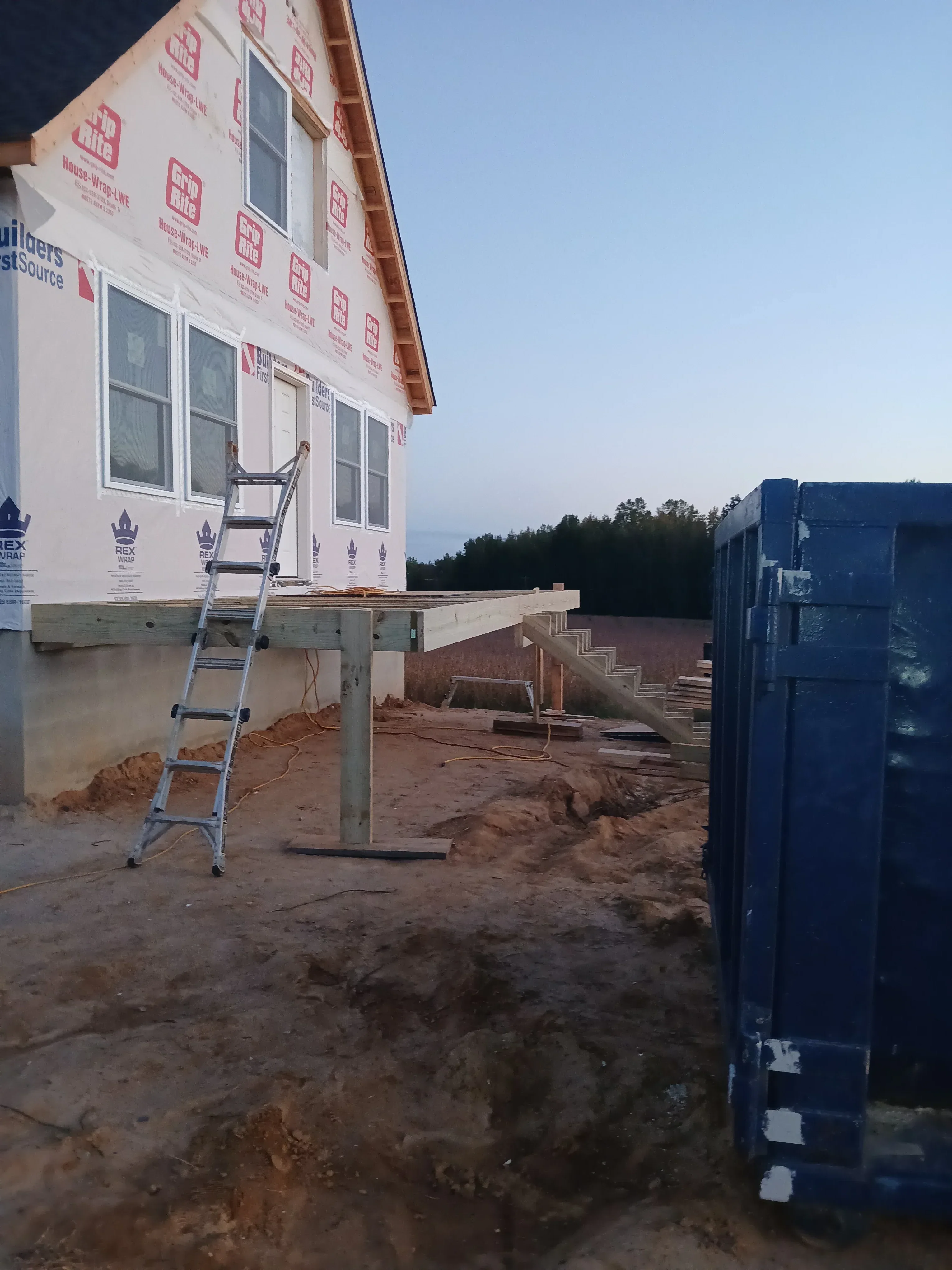 Residential framing with housewrap, window openings, and safety railings during construction