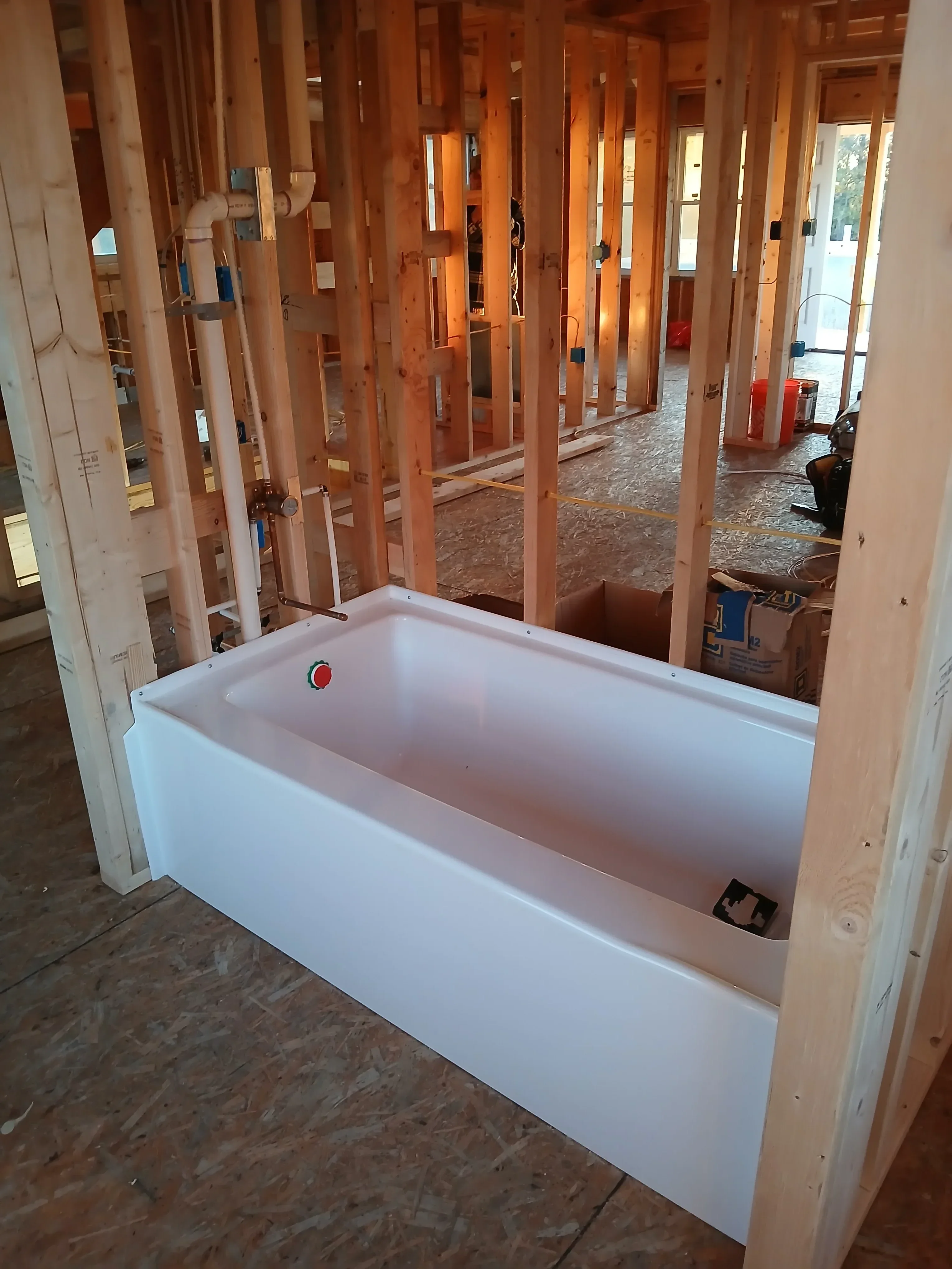 Interior framing with wood studs and newly installed white drywall on walls and ceiling