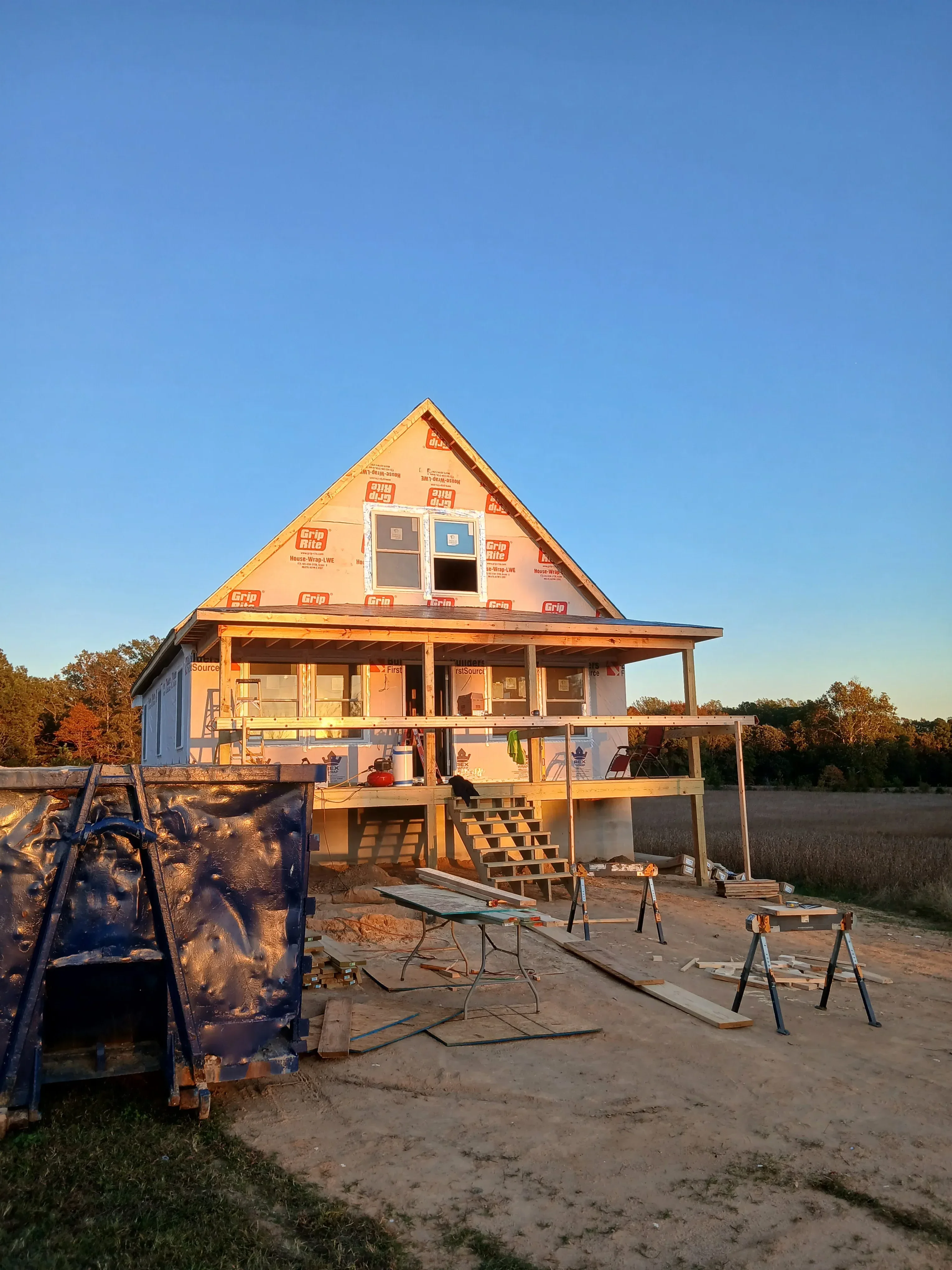 Residential home framing with wooden structure, trusses, and weather wrap installed