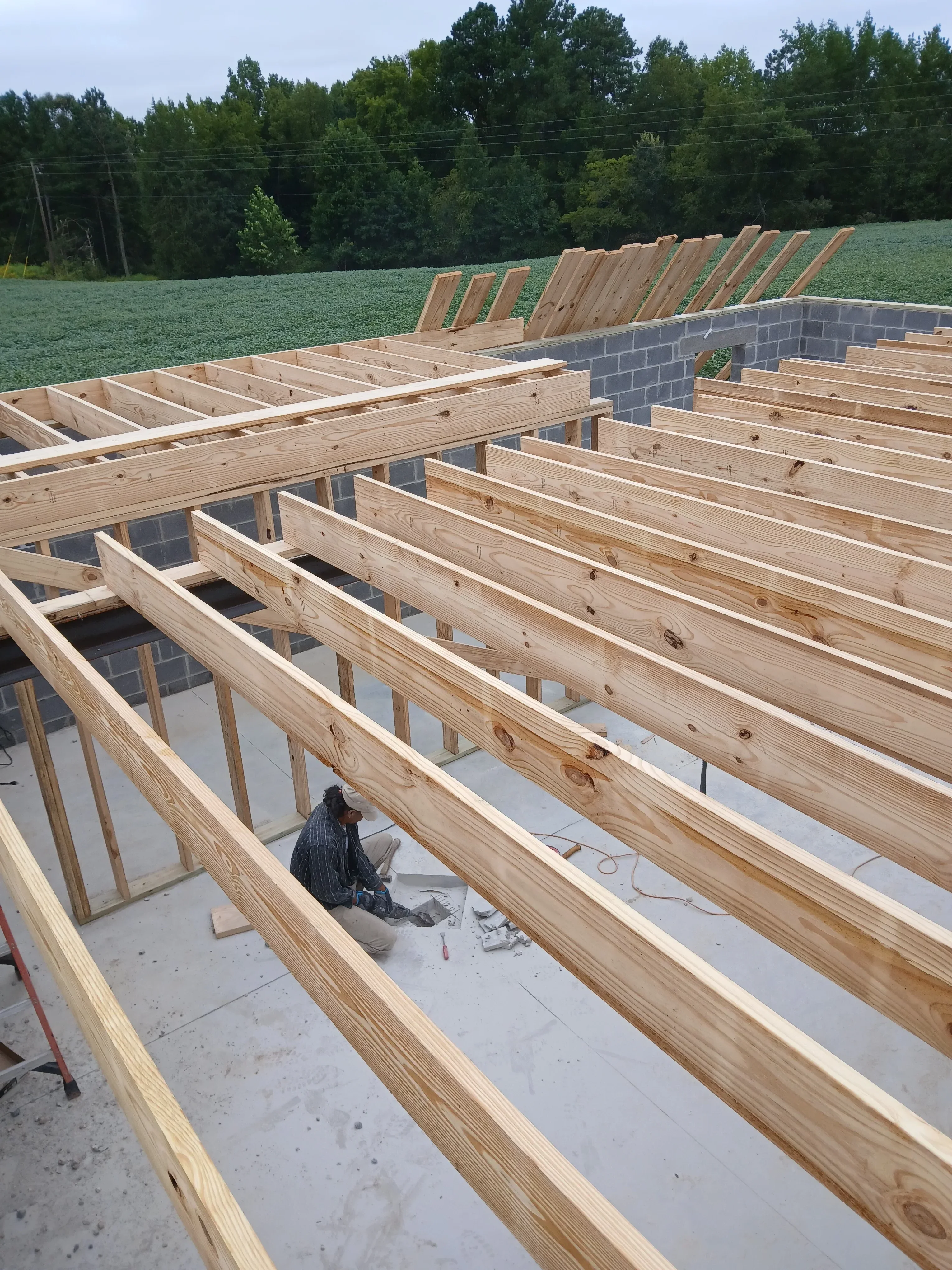 Wooden roof framing with rafters, collar ties, and structural bracing during installation