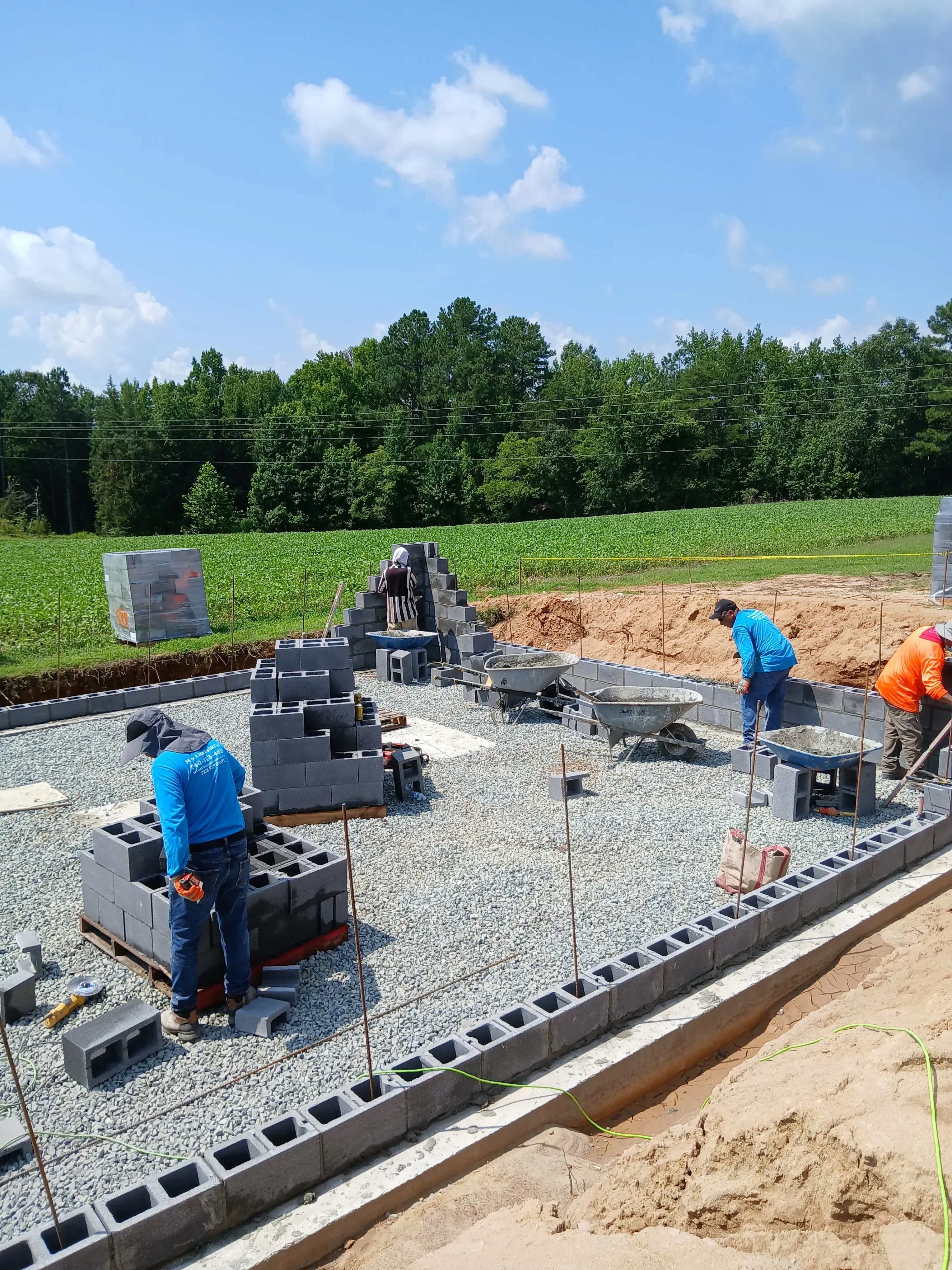 Gray paver driveway installation with gravel base, plastic edging, and fresh sod landscaping