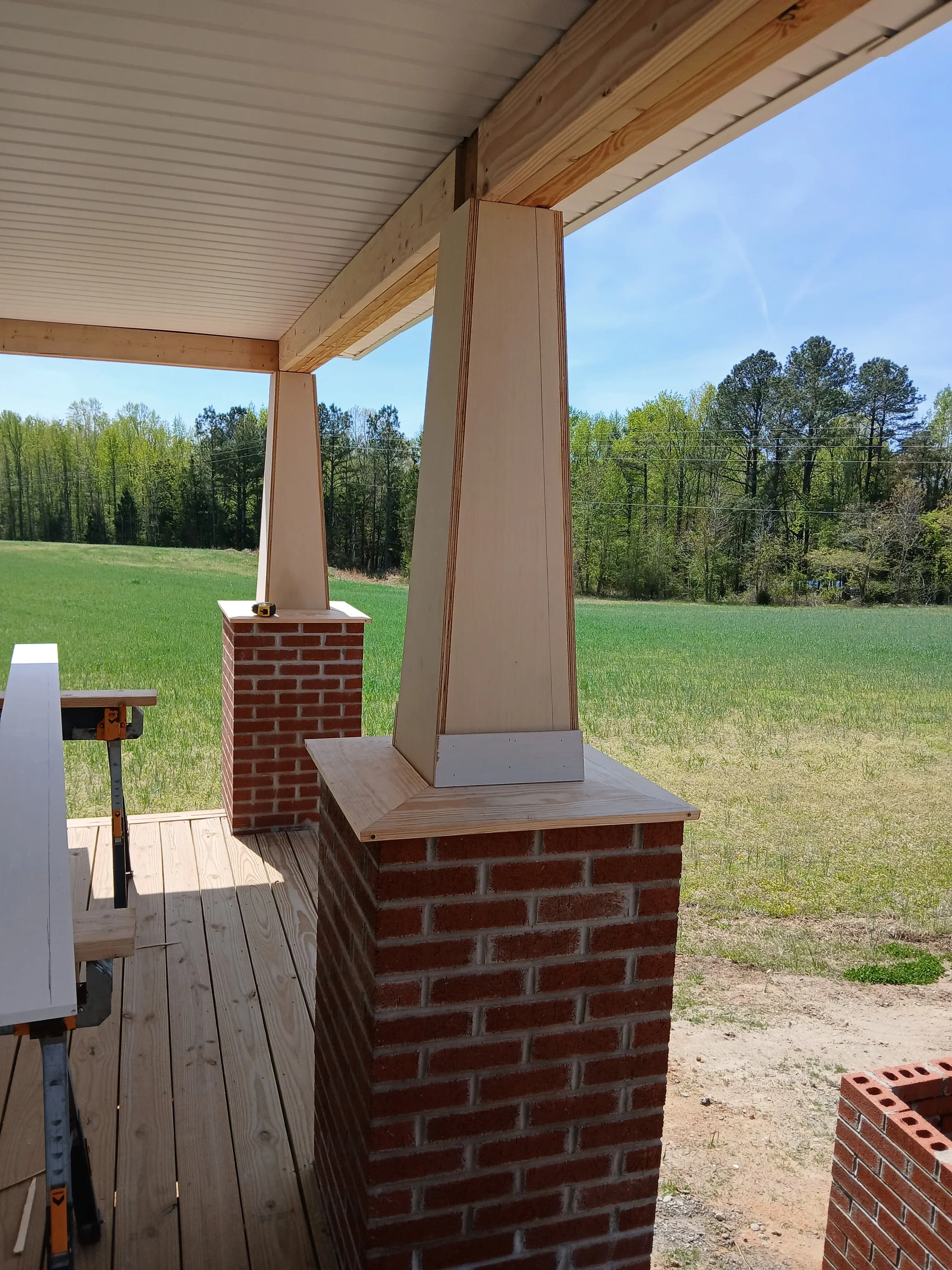 Brick chimney with wood soffit framing and metal flashing installation on residential exterior