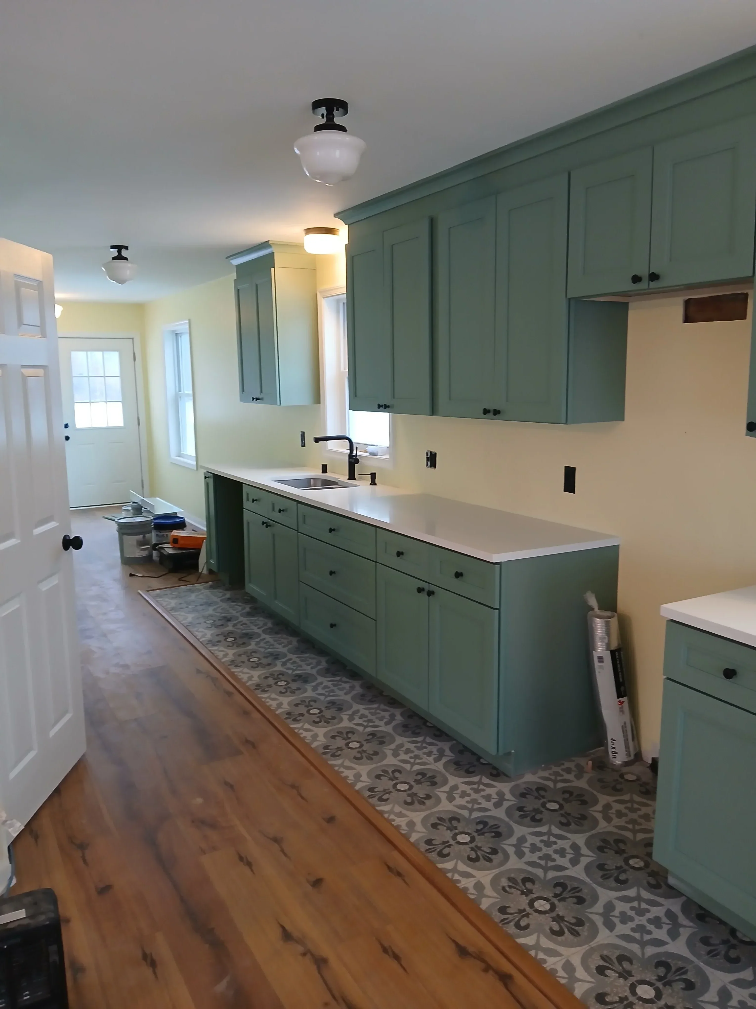 Kitchen with sage green cabinets, cream walls, recessed lighting, and hardwood flooring