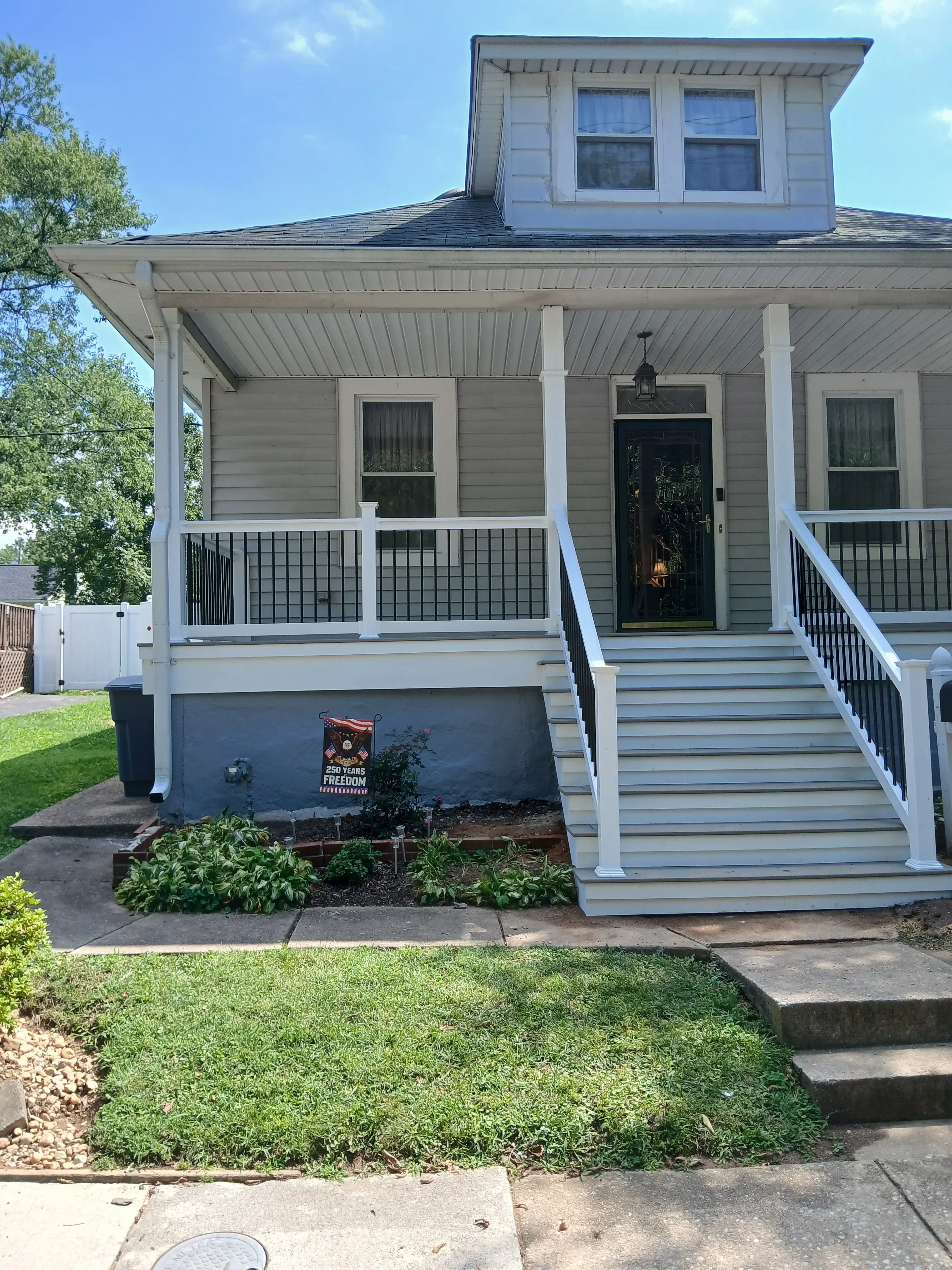 Gray and white vertical metal siding with white deck framing and composite decking on residential home