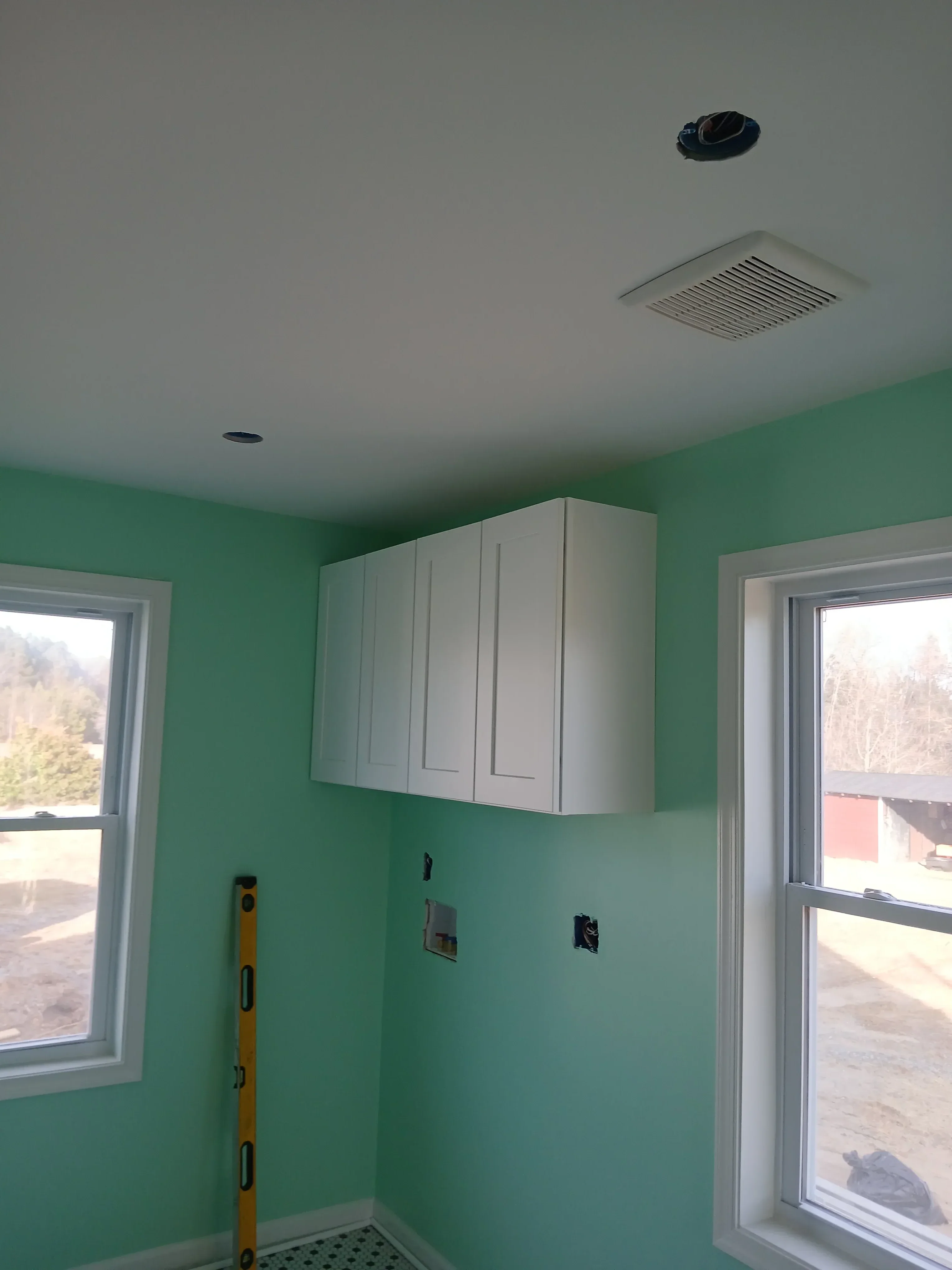 Green drywall walls and ceiling with electrical outlets, skylight, and HVAC ductwork installation