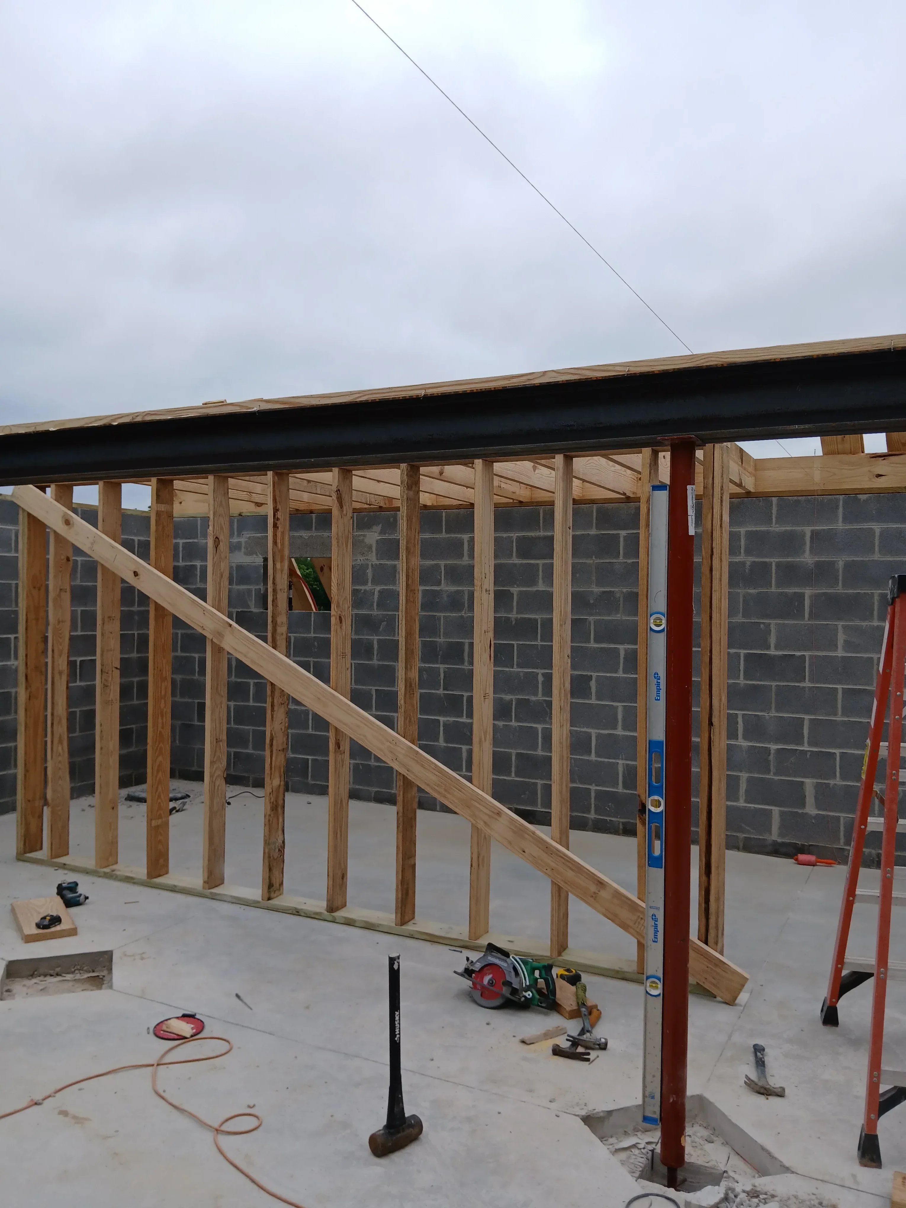 Wooden roof framing with joists, rafters, and level bracing during construction